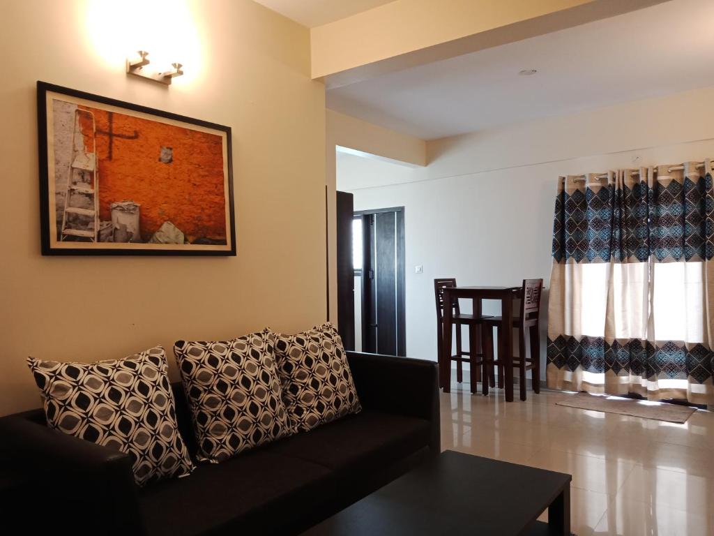 - un salon avec un canapé et une table dans l'établissement Tranquil Serviced Apartments, à Bangalore