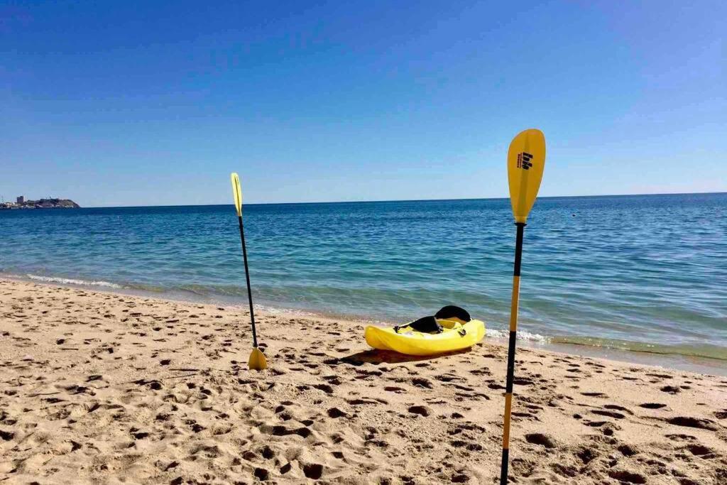 eine Person, die am Strand neben zwei Paddeln liegt in der Unterkunft NEW 2 BEDROOM LUXURY APARTMENT -GREAT LOCATION -MODERN in Puerto Peñasco