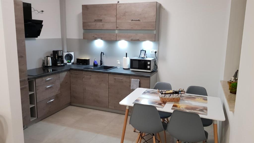 a small kitchen with a table and chairs at Apartament Fibra Frappe in Rybnik