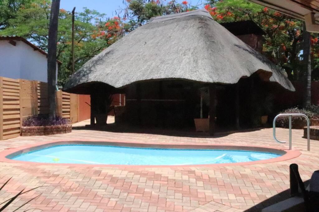 mały basen z dachem krytym strzechą w obiekcie Die Huis - Self Catering w mieście Bela-Bela