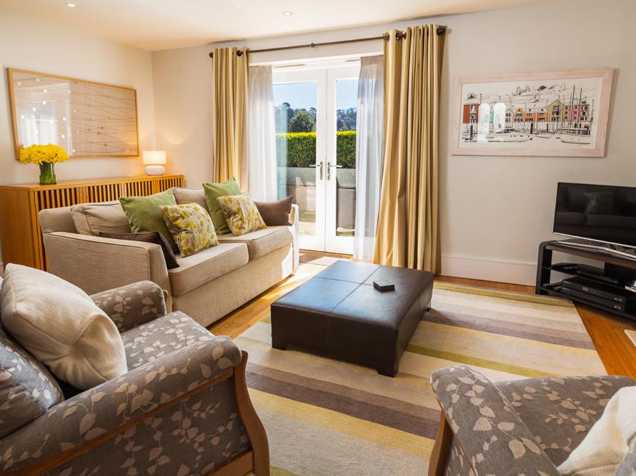 a living room with two couches and a television at 4 Dart Marina in Dartmouth