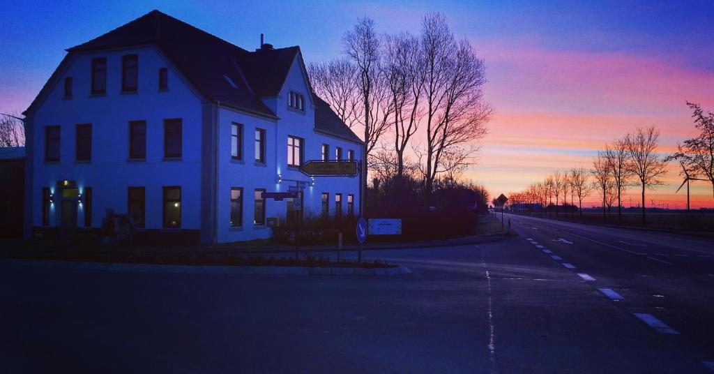 een wit huis aan de kant van een weg bij Ahoi in Wesselburenerkoog