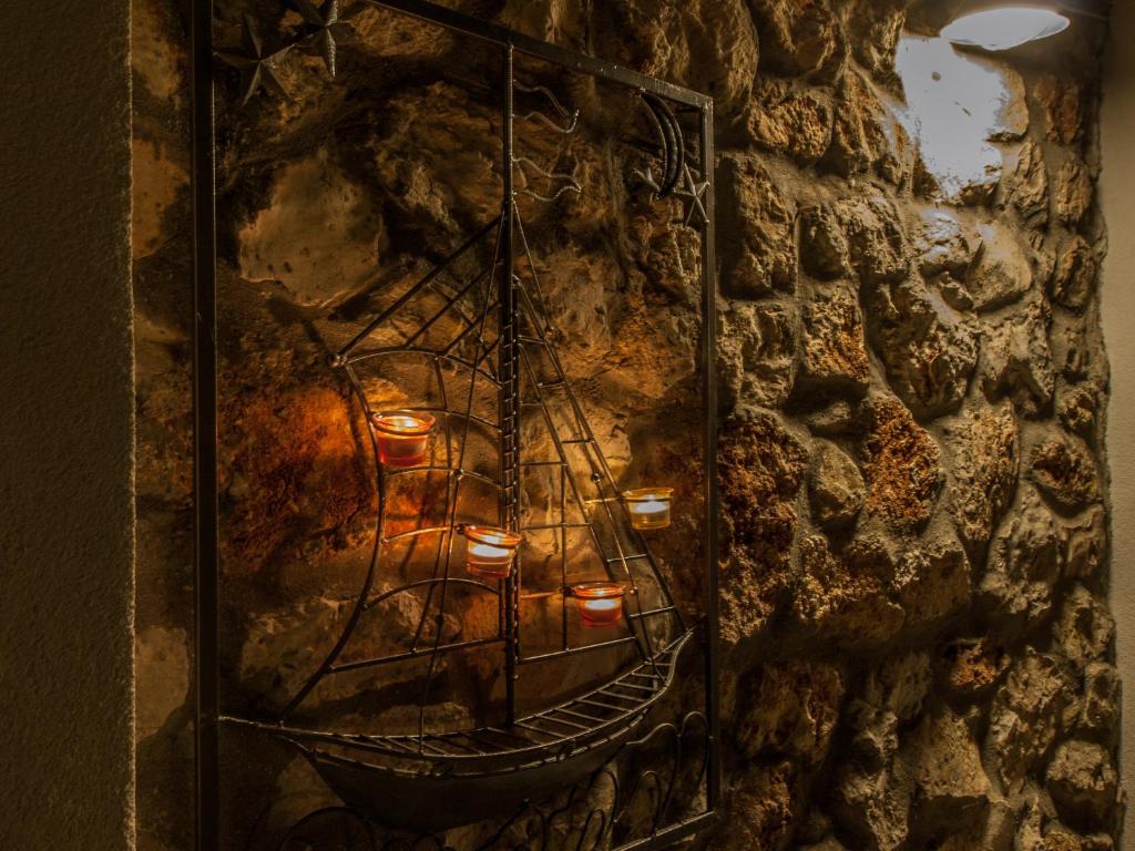 a candlelight vigil in a stone wall with a boat on it at Silba Otium in Silba