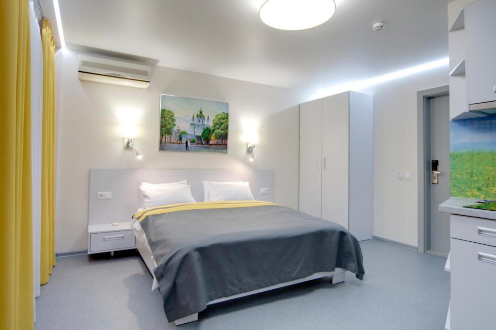 1 dormitorio con 1 cama y una pintura en la pared en Arena Summit Apart Hotel en Kiev