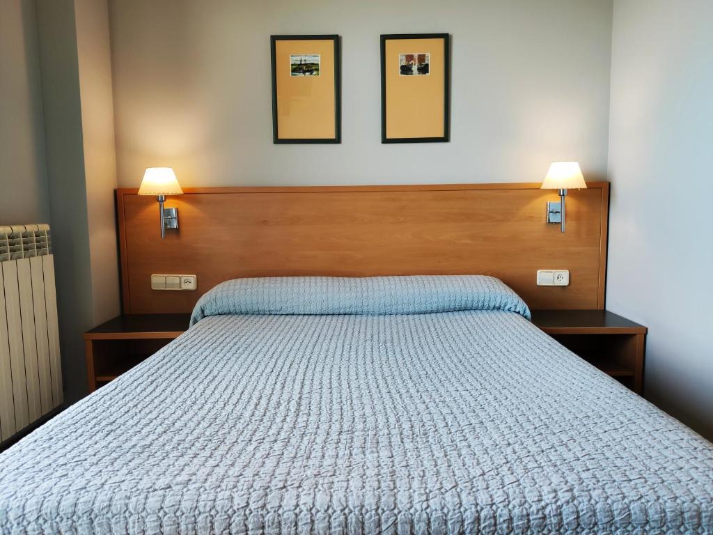 Hotel Área de Calahorra في كالاهورا: غرفة نوم بها سرير وعليها مصباحين