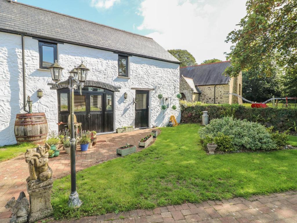 a white brick house with a garden in front of it at Primose Cottage in Milford Haven