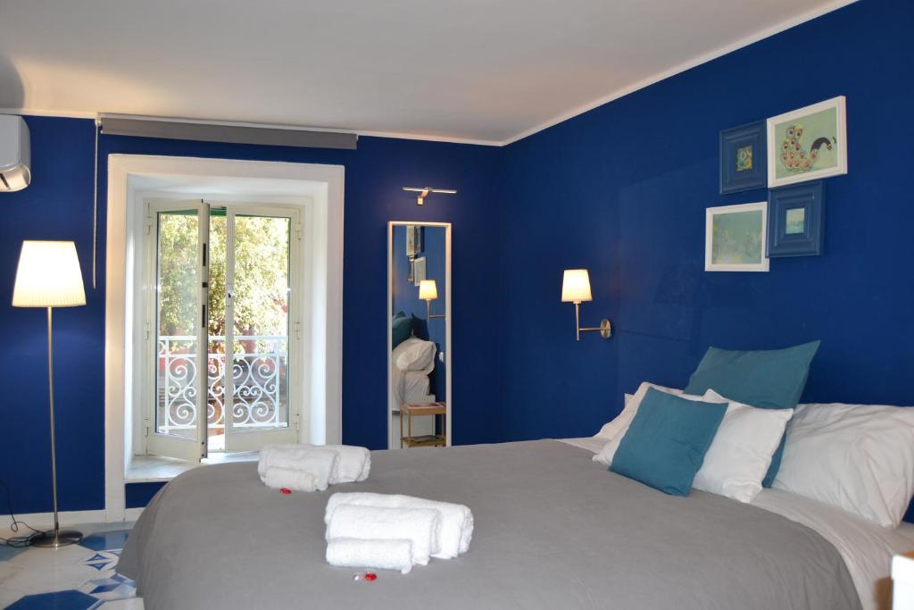 a blue bedroom with a bed with towels on it at Be Blu Apartment in Naples