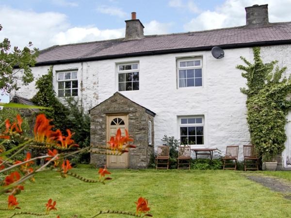 a white house with chairs and a table in the yard at Harber Scar in Settle