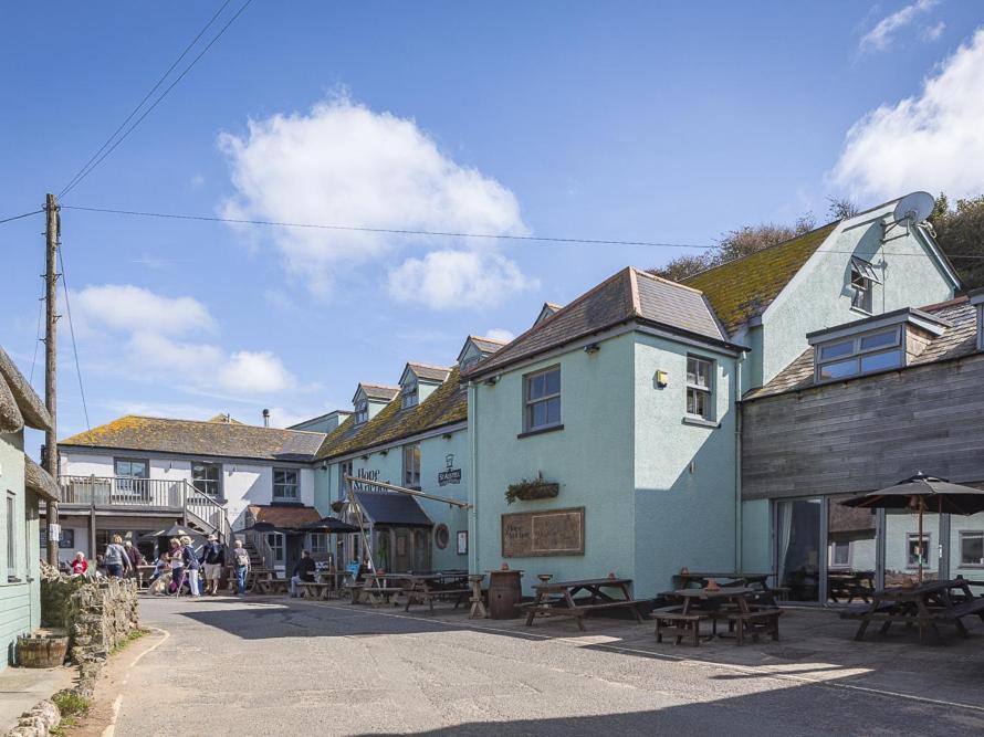 a group of buildings on a street with picnic tables at 4 Armada House in Hope Cove