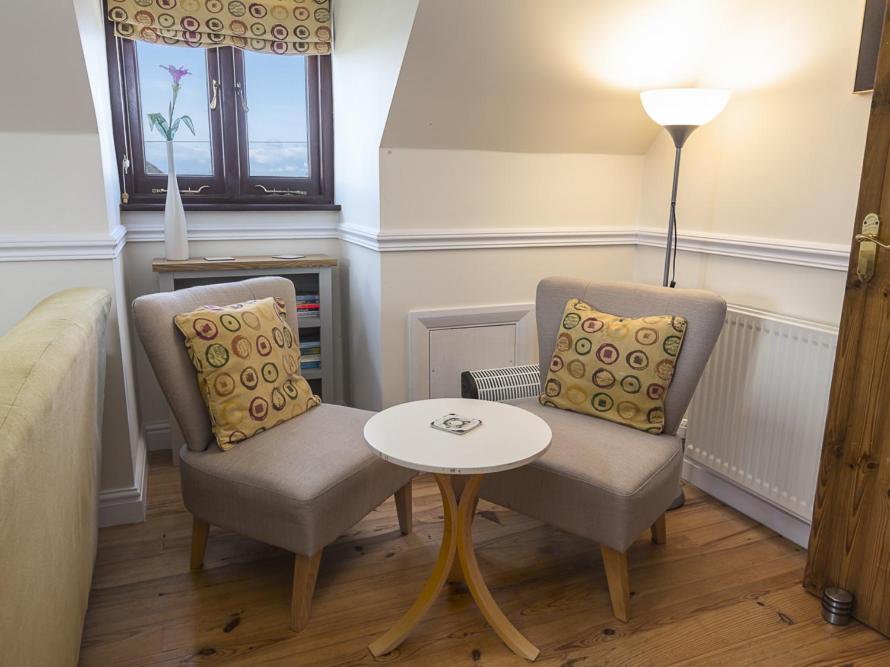 a living room with two chairs and a table at 4 Armada House in Hope Cove