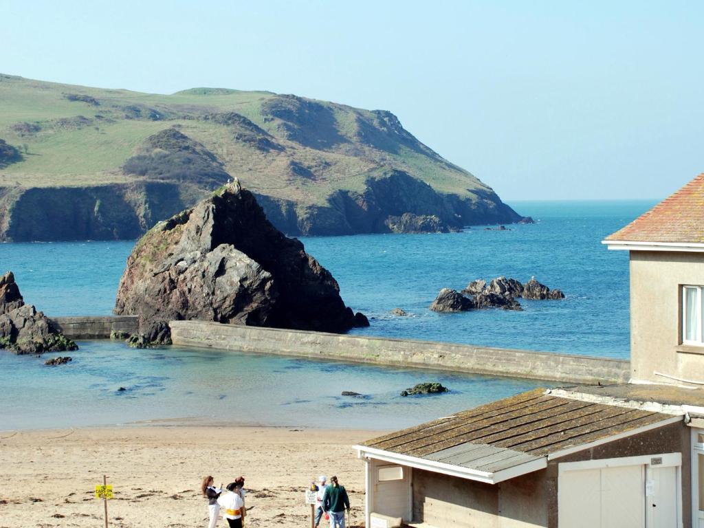 a group of people standing on a beach near the ocean at 4 Armada House in Hope Cove