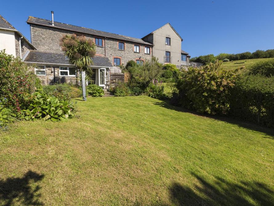 a house on a hill with a large yard at Hazel Cottage in Malborough