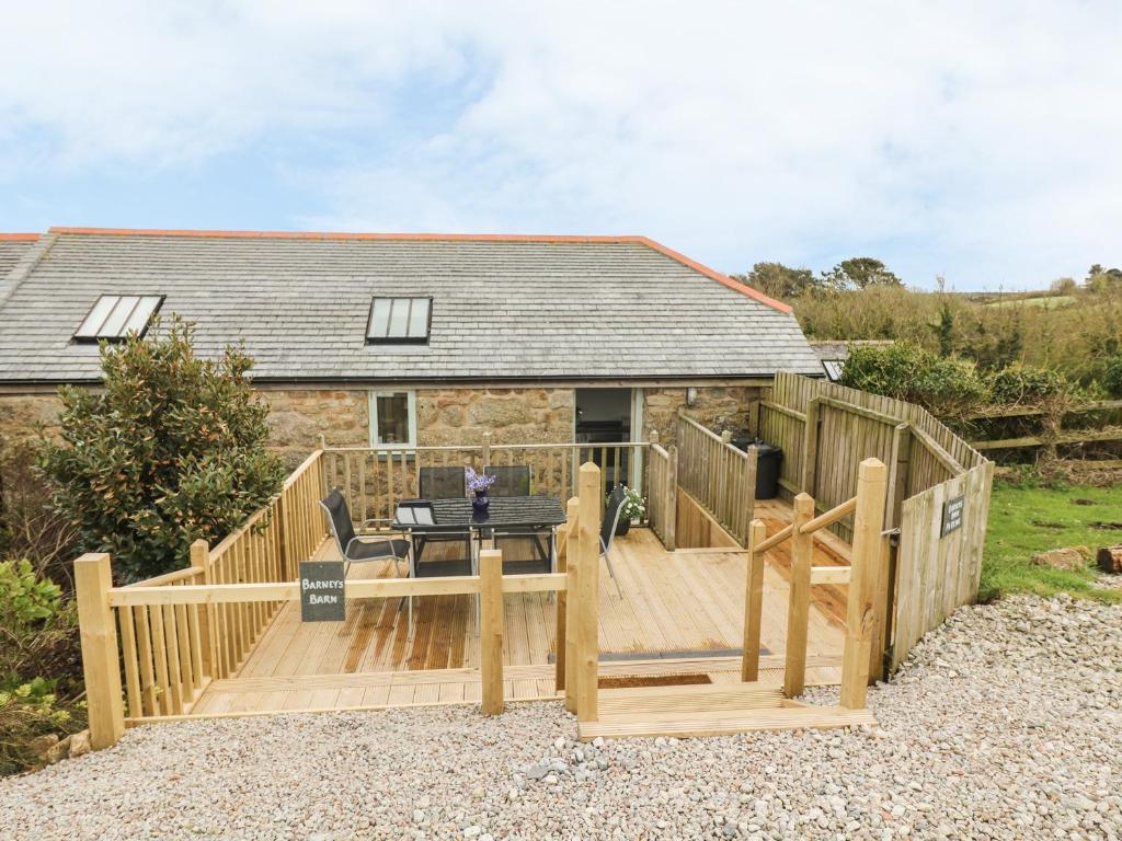 a large wooden deck in front of a house at Barneys Barn in Penzance