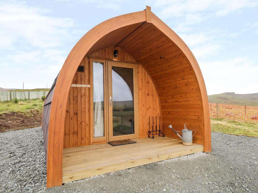 a small wooden building with a large window at Garraidh Ghorm Pod in Portree