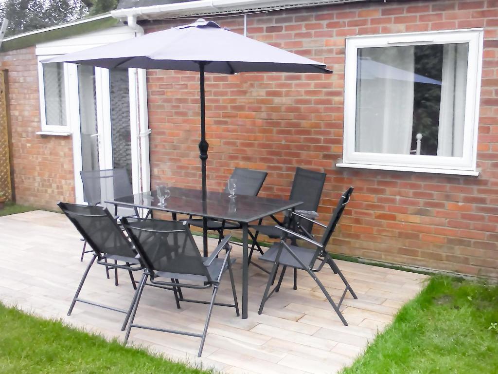 un tavolo e sedie con ombrellone su un patio di The Old Clockmakers a Norwich