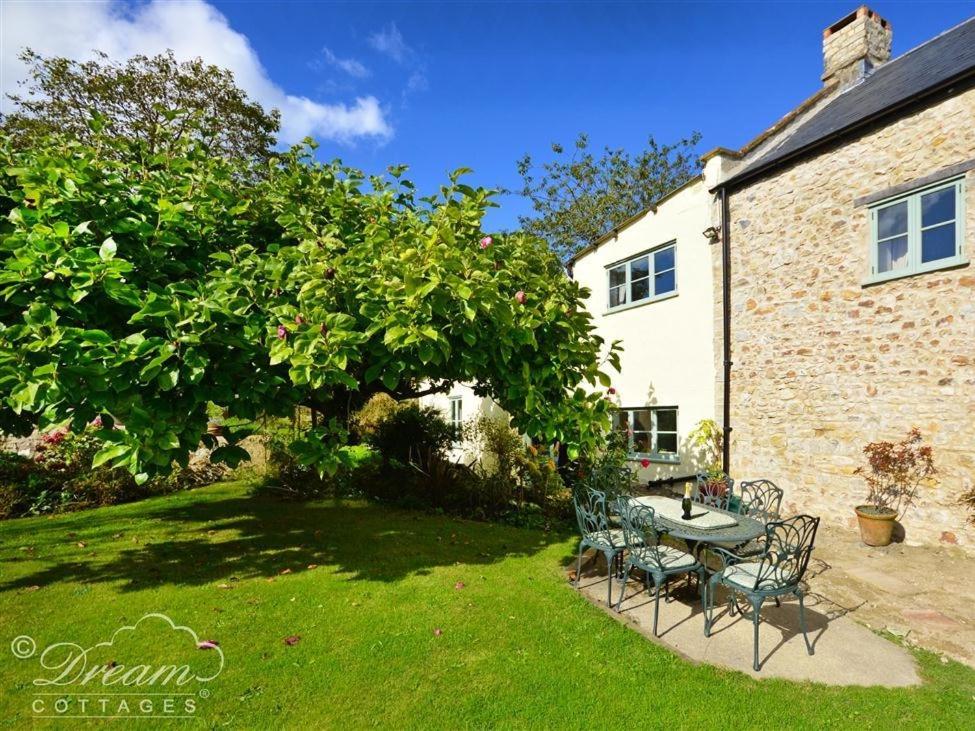 a table and chairs in the yard of a house at Valley View Farm Annexe in Uplyme