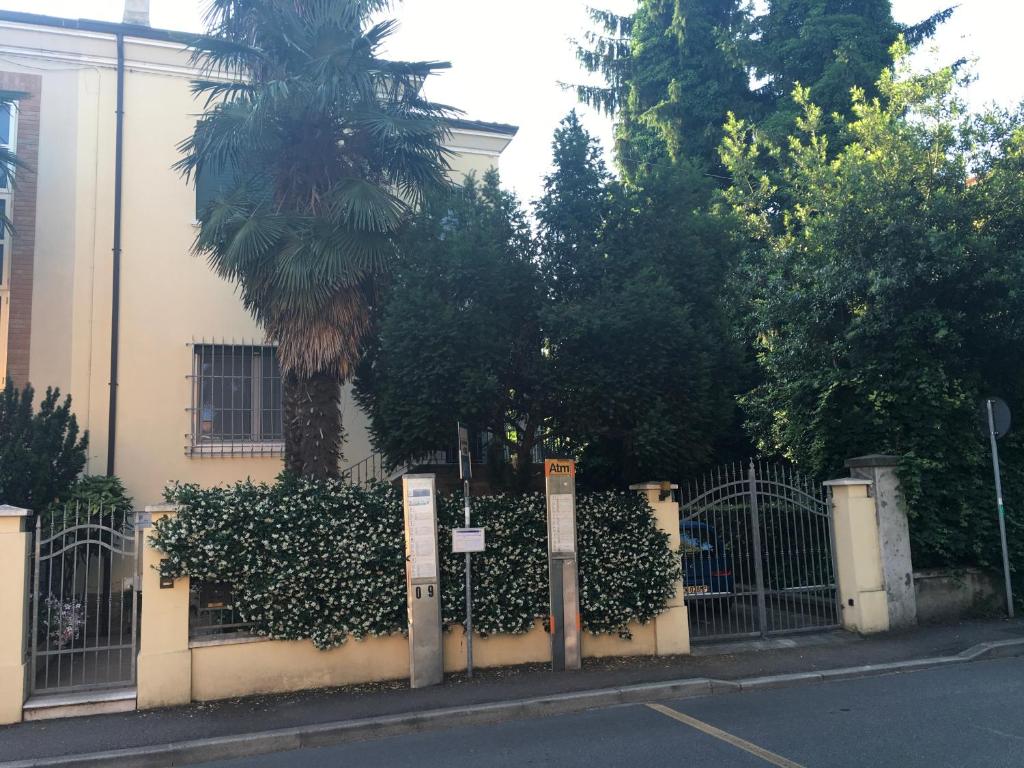a fence with a palm tree in front of a building at Casa di Anna in Ravenna