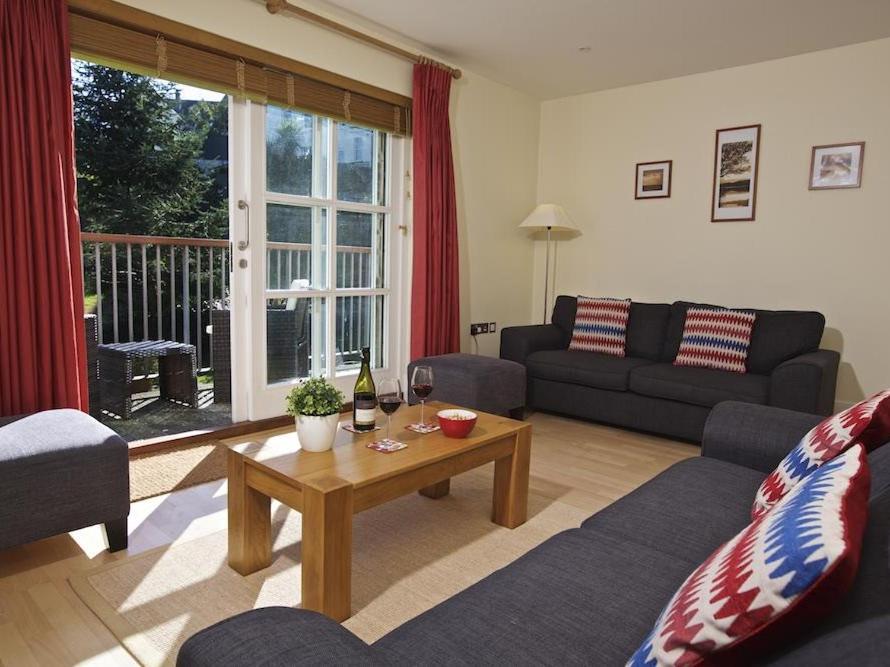 a living room with a couch and a table at 1 Combehaven in Salcombe