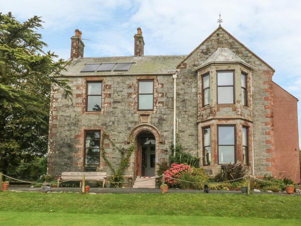 an old stone house with solar panels on it at Hillcrest in Newton Stewart