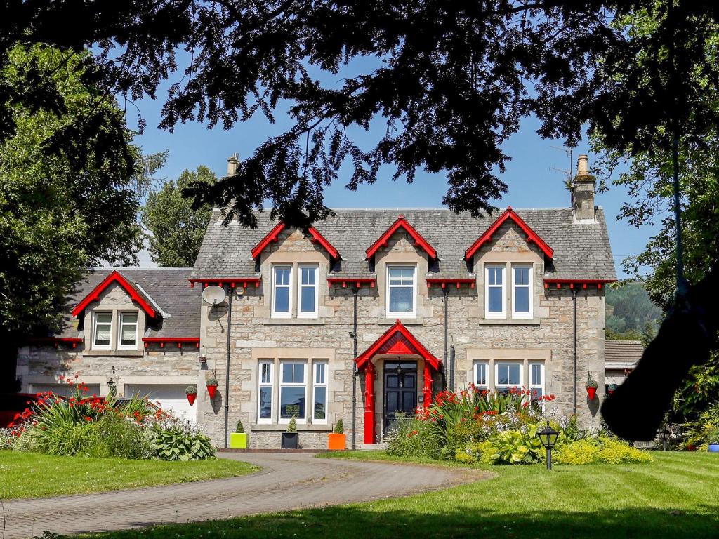 a large stone house with red trim at Roseburn in Pitlochry