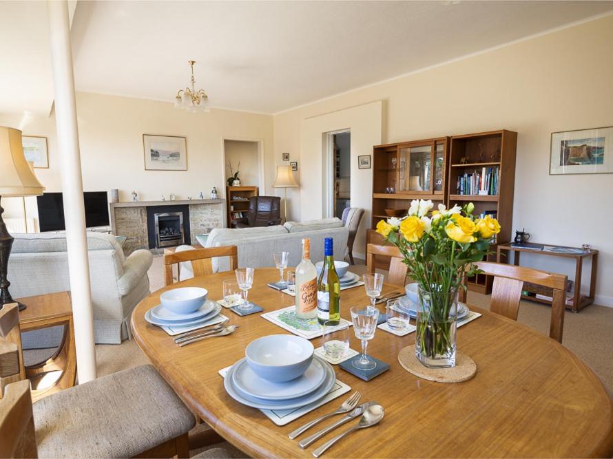 uma sala de estar com uma mesa de madeira com flores amarelas em 5 Fairhaven em Salcombe