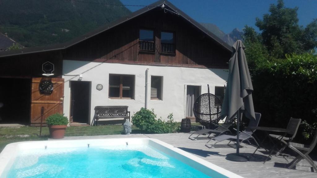 una casa con piscina frente a una casa en fleur de neige, en Gilly-sur-Isère