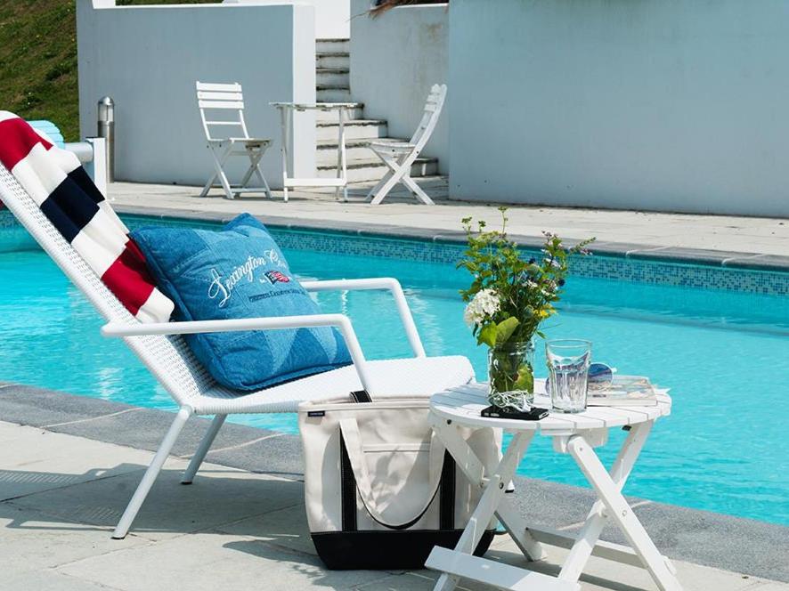 a white chair and a table next to a pool at 9 Prospect House in Kingsbridge