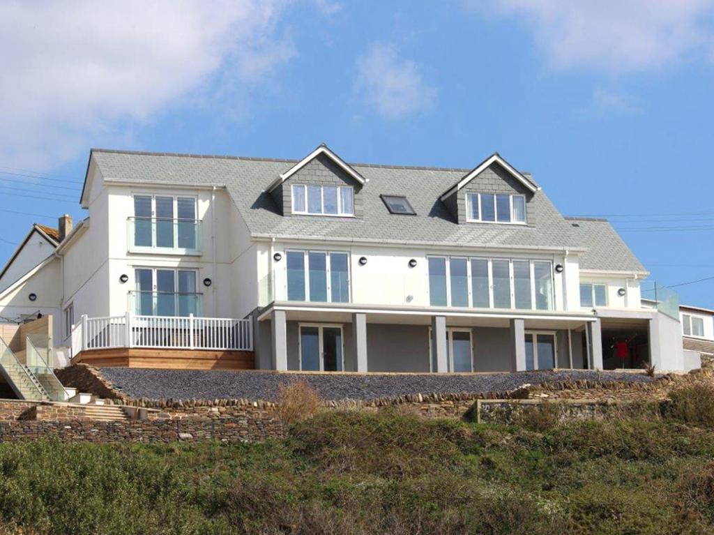 a large house sitting on top of a beach at Seagulls Perch in Mawgan Porth