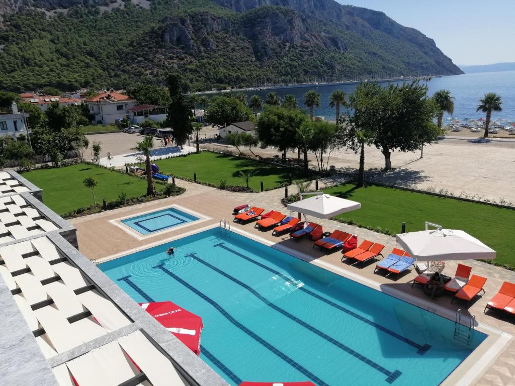 an overhead view of a swimming pool with chairs and the ocean at Doğruer Hotel & Spa in Muğla