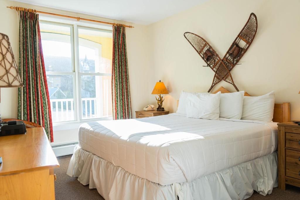 a bedroom with a large white bed and a window at Long Trail House Condominiums at Stratton Mountain Resort in Stratton Mountain