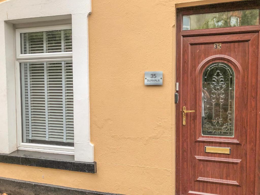 a brown door with a sign on it next to a window at Sunvale in Teignmouth