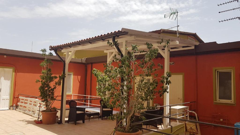 a pergola on a red building with plants at Apartment i viaggi di Mario in Cagliari