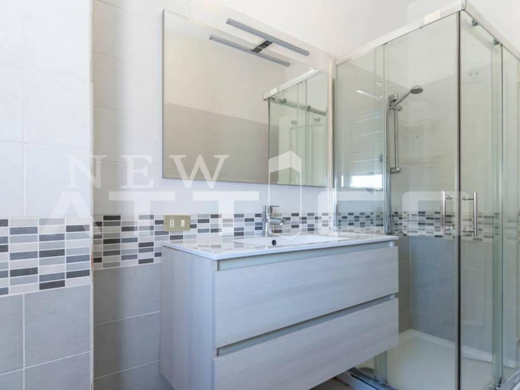 een badkamer met een wastafel en een glazen douche bij appartamento mariani in Riccione