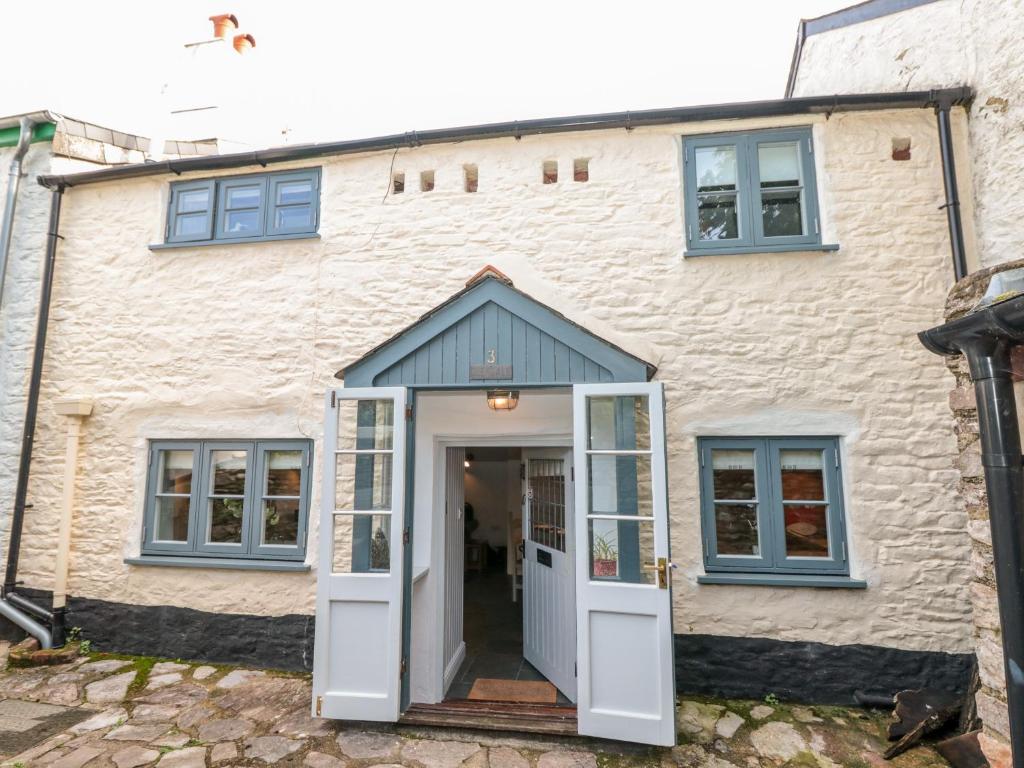 una casa con una puerta y ventanas blancas en 3 Glendale Cottages, en Dartmouth