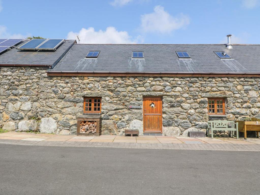 a stone building with a wooden door and windows at Craig Y Deryn in Tywyn