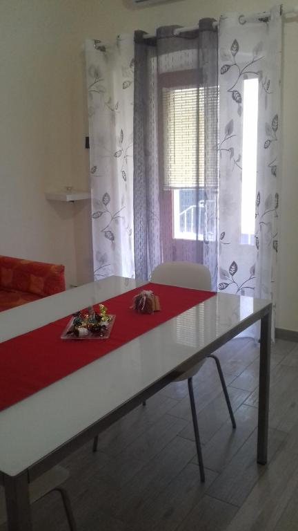 un tavolo in una stanza con una tenda rossa e bianca di Cavour17 a Montescaglioso