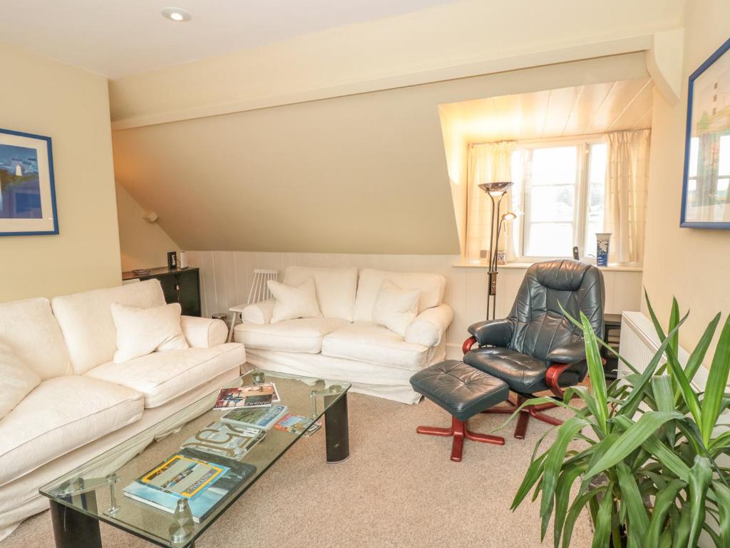 a living room with a white couch and a chair at 5 Island Street in Salcombe