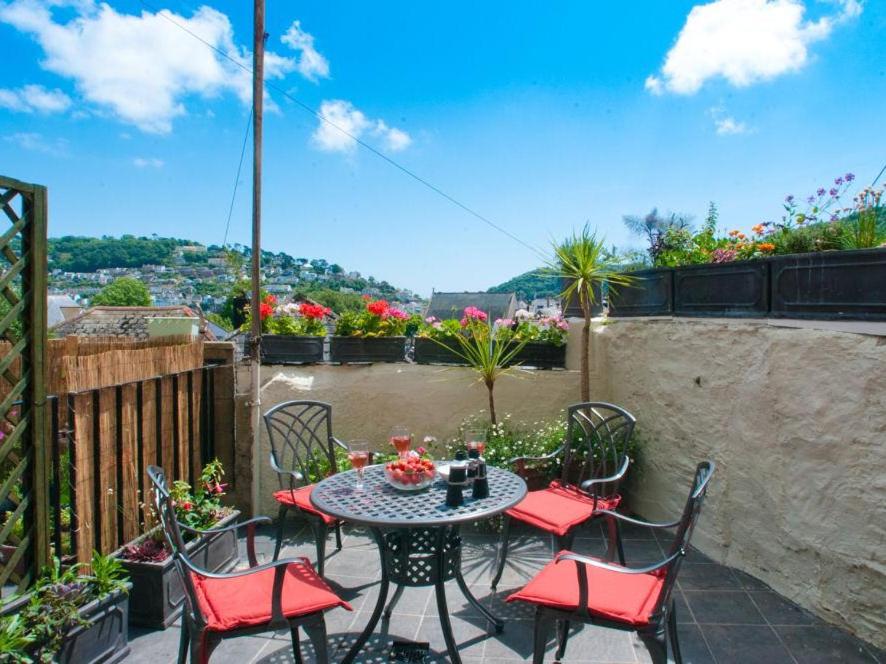 a patio with a table and chairs on a balcony at The Cottage, 13 Clarence Hill in Dartmouth