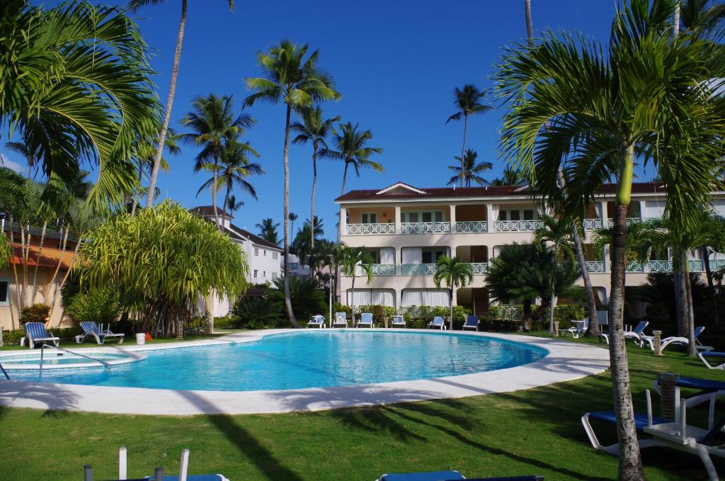 a swimming pool in front of a building with palm trees at Little paradise in middle of beautiful beaches! in Las Terrenas