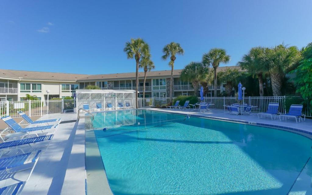 Una gran piscina con sillas y un resort. en King Bed - Walk to St. Armand's Circle and Lido Beach in Minutes!, en Sarasota