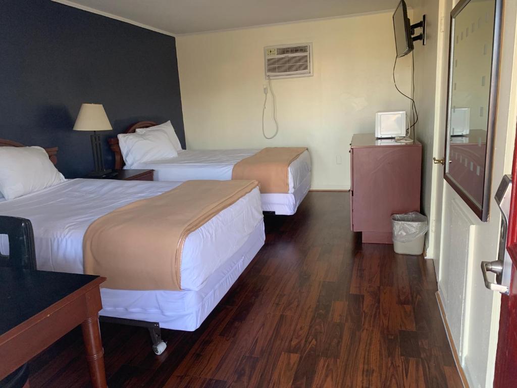 Habitación de hotel con 2 camas y escritorio en Sunset Inn, en Atlantic City