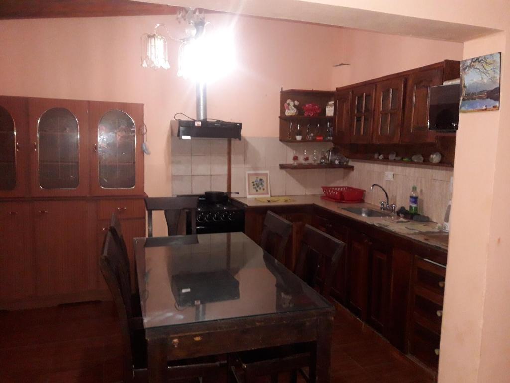 cocina con armarios de madera y encimera en Lo de Charly en Villa Carlos Paz