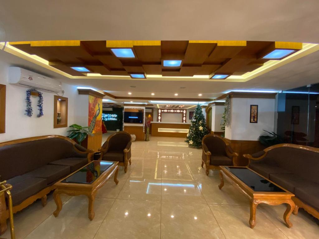 Utsavam Hotel Apartments في غوروفايور: لوبي فيه كنب وطاولات في مبنى