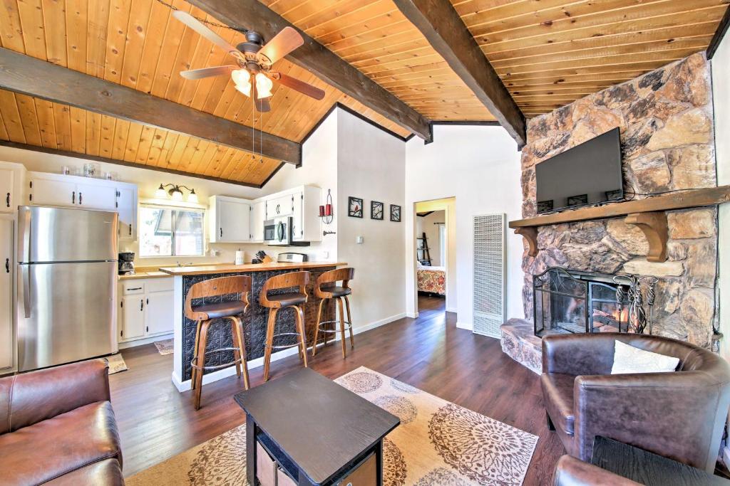 a kitchen and living room with a stone wall at Cozy Cabin with Deck and Fireplace in Big Bear! in Big Bear City