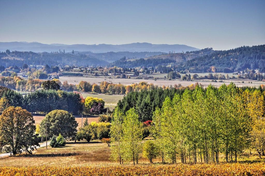 a group of trees in a field with mountains in the background at Chic Willamette Valley Home with Deck and Vineyard! in Gaston