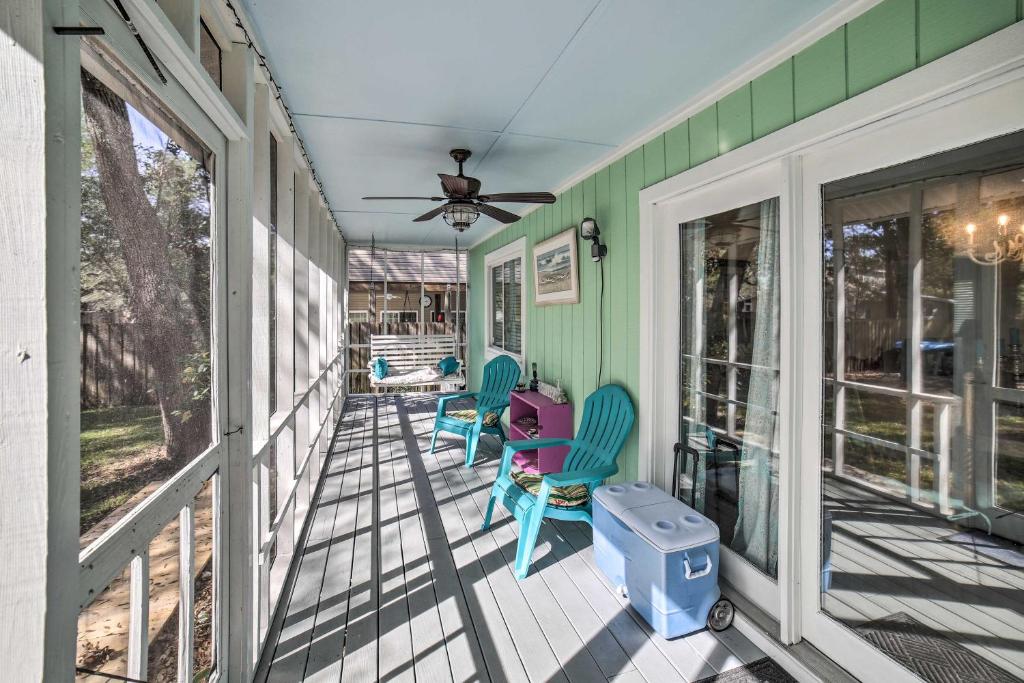 - une terrasse couverte avec des chaises et un ventilateur de plafond dans l'établissement Oak Island Home with Yard Less Than 1 Mi to the Beach!, à Île au chêne