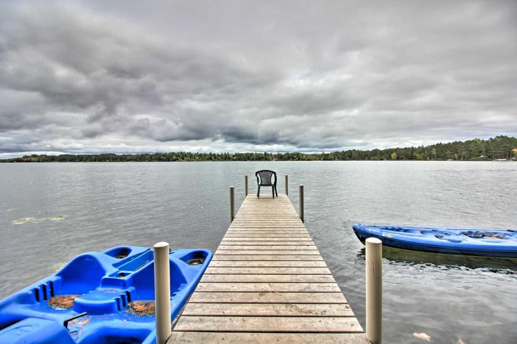 un quai avec deux bateaux bleus sur un lac dans l'établissement Loon Lake Lodge with Dock, Sauna and Hot Tub!, à Pequot Lakes
