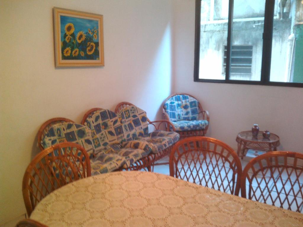 Zimmer mit Stühlen, einem Tisch und einem Fenster in der Unterkunft Apartamento 2 Dormitórios , Enseada , Guarujá, SP, 400 Metros da Praia in Guarujá