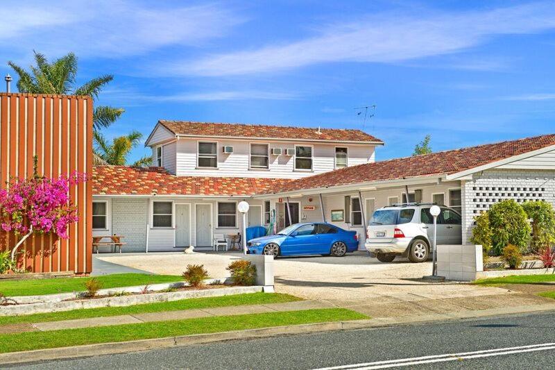 a house with two cars parked in a driveway at The Wauchope Motel in Wauchope