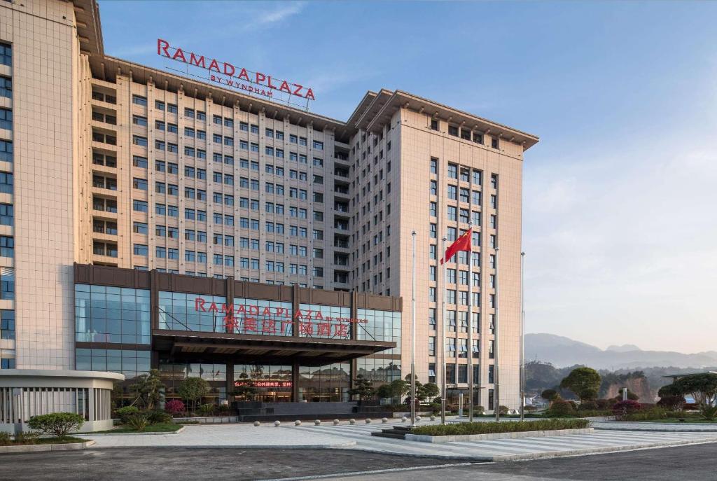 a large building with a sign on top of it at Ramada Plaza by Wyndham Enshi in Enshi